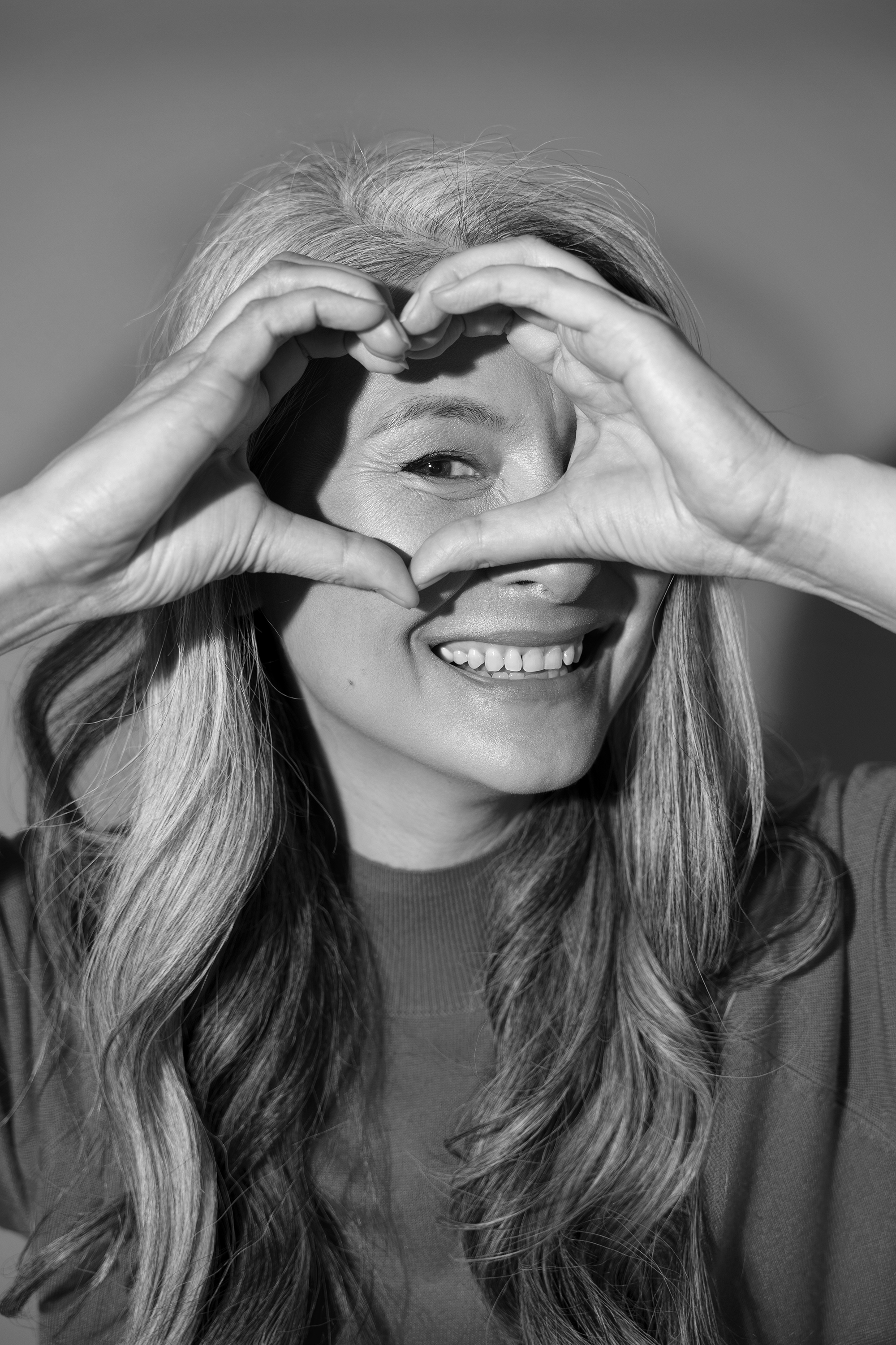 Smiling patient making a heart shape with her hands.