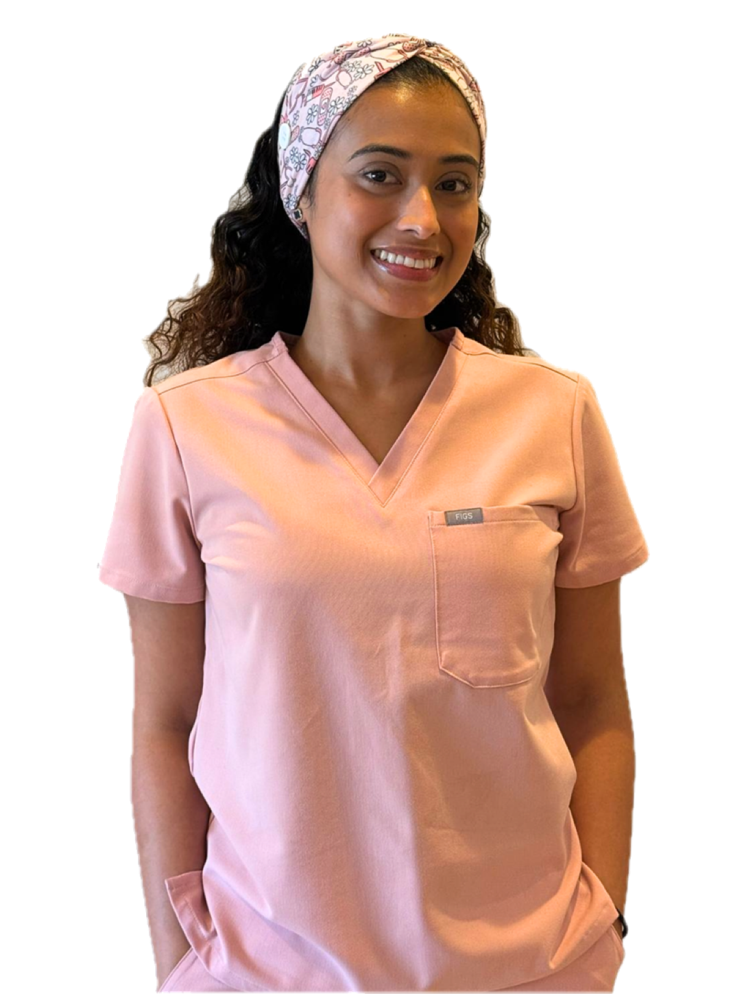 Zayi Pineda smiling in pink clinical scrubs.